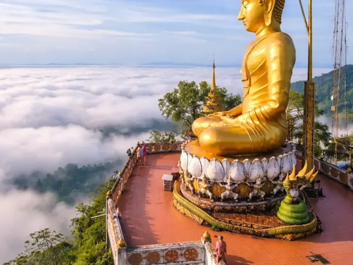 Złoty Budda na szczycie Tiger Cave Temple, w dole morze chmur