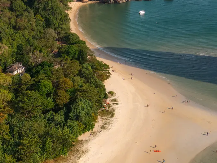 Szeroka piaszczysta plaża z lotu ptaka, spacerowicze przy linii wody
